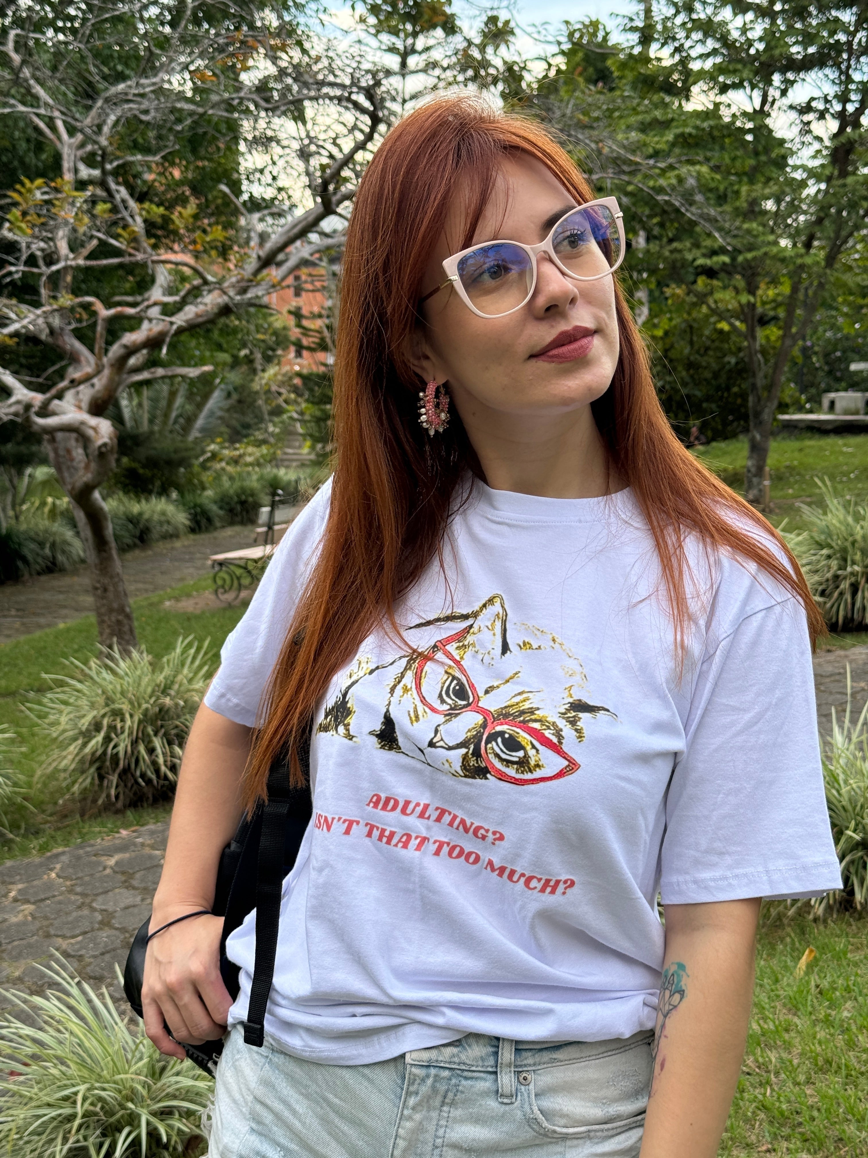 Nuestra modelo usando nuestra camisa blanca con un diseño de colores brillantes con un fondo boscoso